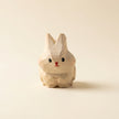Wooden rabbit figurine on a beige background