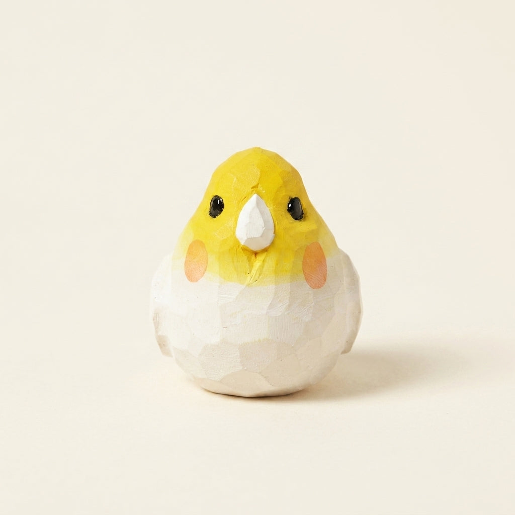 Small ceramic bird figurine with a yellow head and white body on a beige background